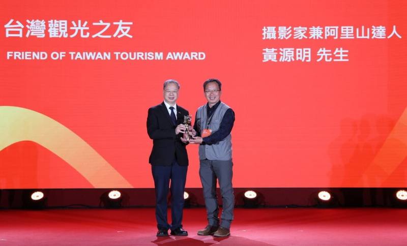阿里山攝影達人黃源明（右）用鏡頭記錄、推廣阿里山美景，獲交通部觀光署114年度台灣觀光之友，10日在台北圓山大飯店接受表揚。左為行政院秘書長龔明鑫。（觀光署提供）