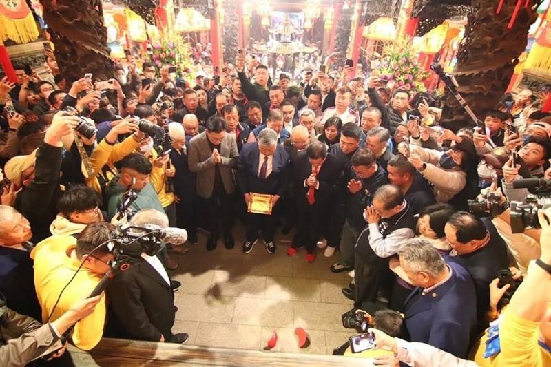 Worshippers gather to witness the results after Yen Ching-piao, chairman of the Jenn Lann Temple board, cast two crescent-shaped divining blocks onto the ground before the statue of Mazu during a ceremony seeking divine guidance for this year's pilgrimage