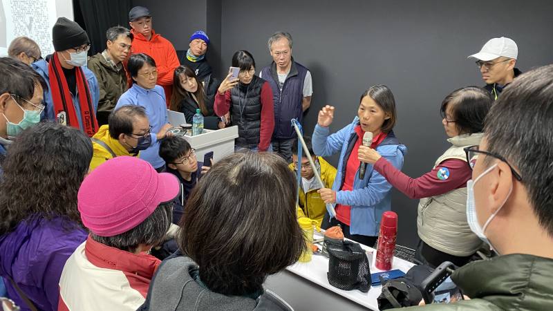 冒險精靈國際旅行社李美涼執行長展示各式裝備之用途，民眾圍觀學習並且詢問，講師不藏私分享許多使用技巧