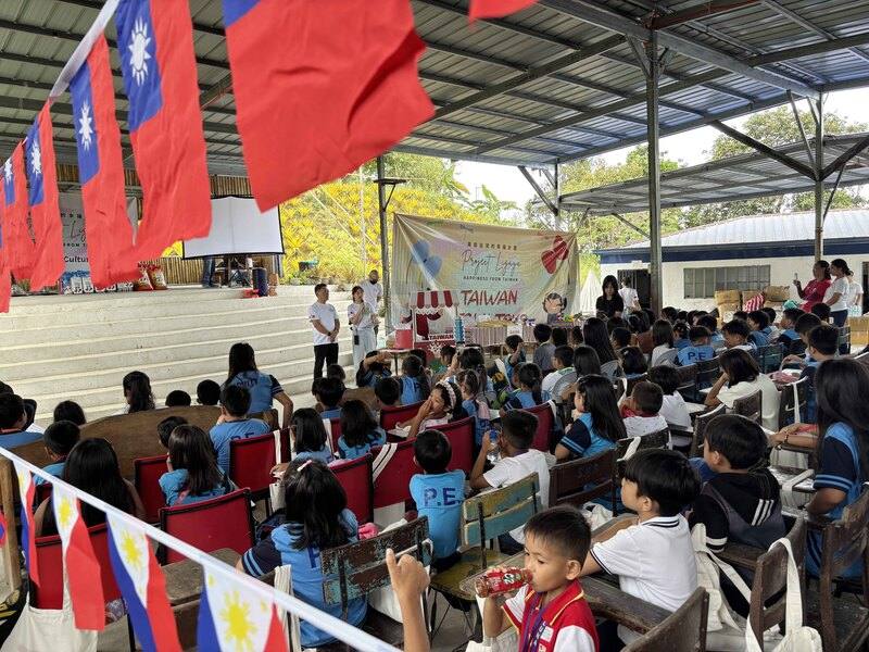 旅菲青年台商21日在馬尼拉以北山區舉辦「幸福計畫．台灣日」活動，百餘名當地偏鄉小學生透過童玩、零嘴與美食體驗台灣文化，留下快樂回憶