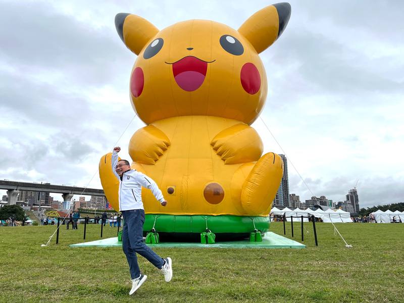 「Pokémon GO Tour：合眾地區」活動21日在新北大都會公園登場，現場有大型皮卡丘充氣裝置，市長侯友宜（前）開心玩起跳拍