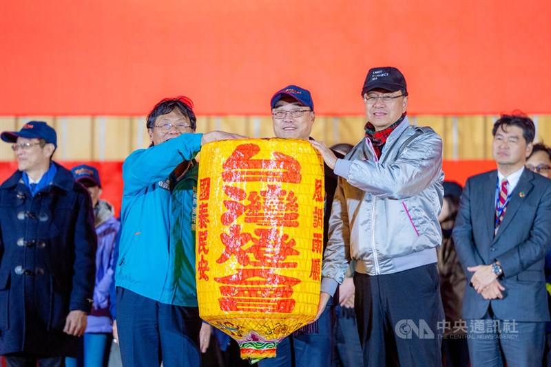 Taoyuan Mayor Chang San-cheng (second right) presents a yellow lantern to Chiayi County Deputy Commissioner Liu Pei-tung (second left) in a ceremonial passing of the lantern to next year's Taiwan Lantern Festival host city Chiayi on Sunday, in the presenc