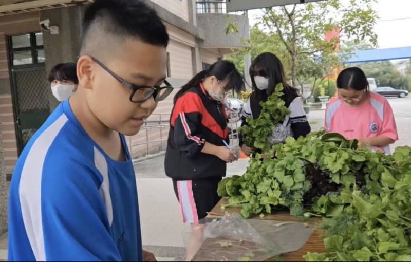 高雄市燕巢國中善用校園空間建置魚菜共生系統，校方說明，學生上學期運用自種蔬菜製作漢堡，親身體驗從產地到餐桌過程；這學期則挑戰農產行銷，學習如何自產自銷推廣至社區，深化食農教育實踐經驗。（燕巢國中提供）