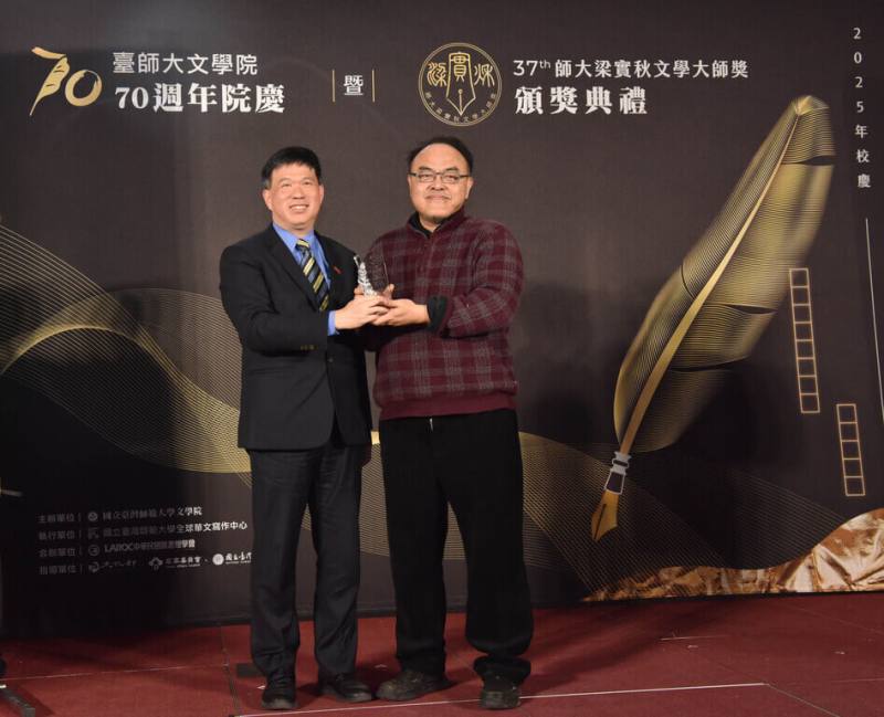 梁實秋文學大師獎19日舉行頒獎典禮，作家駱以軍（右）以「如何抵達人心，如何為愛畫刻度：駱以軍的文學啟蒙小說26講」獲散文首獎，由台師大文學院長須文蔚（左）代表致贈獎座。（台師大全球華文寫作中心提供）
