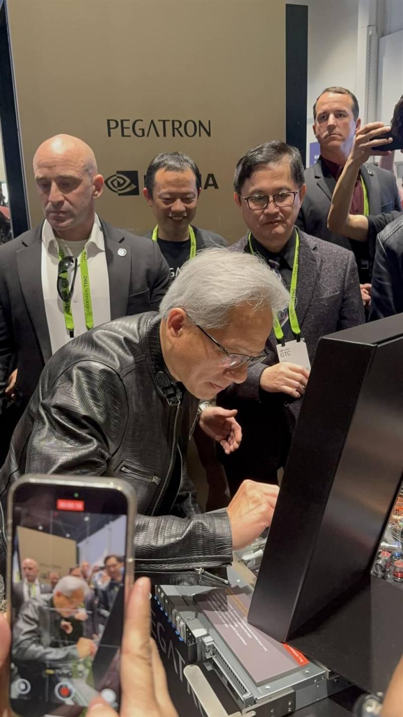 黃仁勳20日造訪輝達GTC大會和碩展位，和碩董事長童子賢（右後）親迎，黃仁勳在機櫃上簽名。（和碩提供）