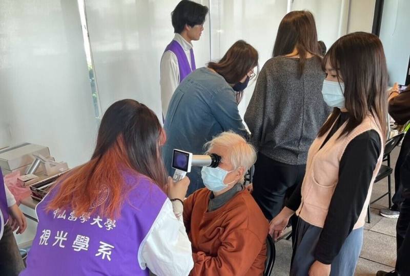 中山醫學大學醫學科技學院師生21日在合勤共生宅烏日館舉辦社區聯合篩檢活動，以專業醫學技術結合關懷社會的精神，為長輩提供健康檢查與衛教指導。圖為視光系為長輩進行視力評估。（中山醫學大學提供）