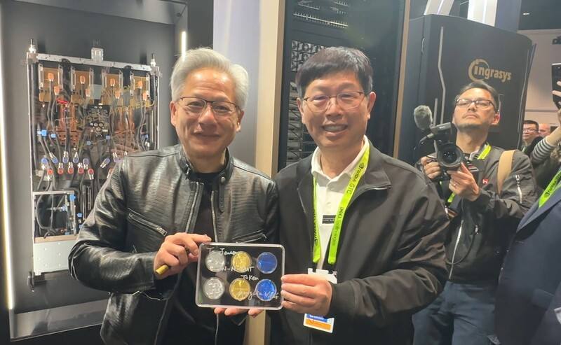 輝達執行長黃仁勳（左）20日參觀鴻海展位，鴻海董事長劉揚偉致贈「鴻海巧克力」，黃仁勳開心表示像實體Token