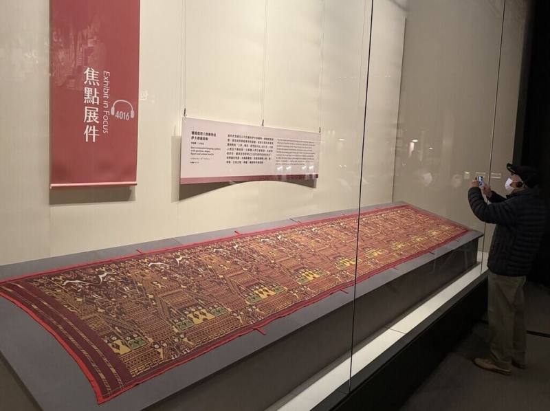 故宮博物院南部院區「包羅萬象－院藏亞洲織品展」即日起全新換展，焦點展件是柬埔寨佛寺掛飾「樓閣寶塔人物動物紋伊卡禮儀掛飾」，總長度超過5公尺，運用繁複的緯向伊卡技法，以蠶絲製成。（故宮南院提供）