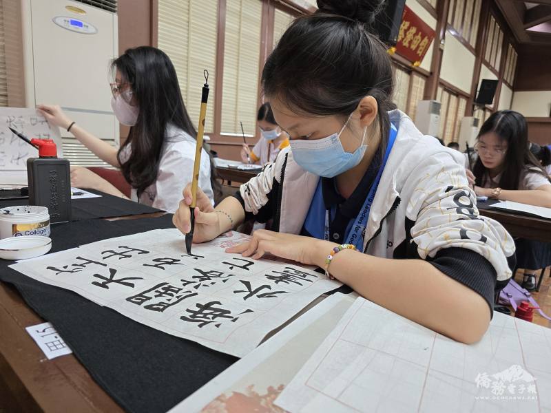 參賽者在主辦單位所分發的大楷紙上揮毫