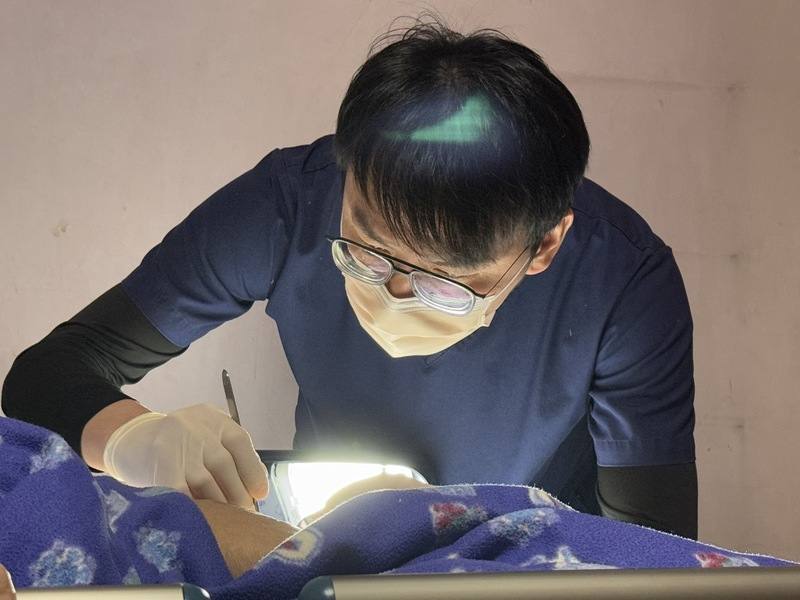 受限於個案居家不像診所有標準化的設備，燈光、空間和環境各有差異，雲林縣「好所宅」到宅支援診所長黃子華（圖）隨機應變，將長者的臥室變成開刀房，檯燈成為照明燈。