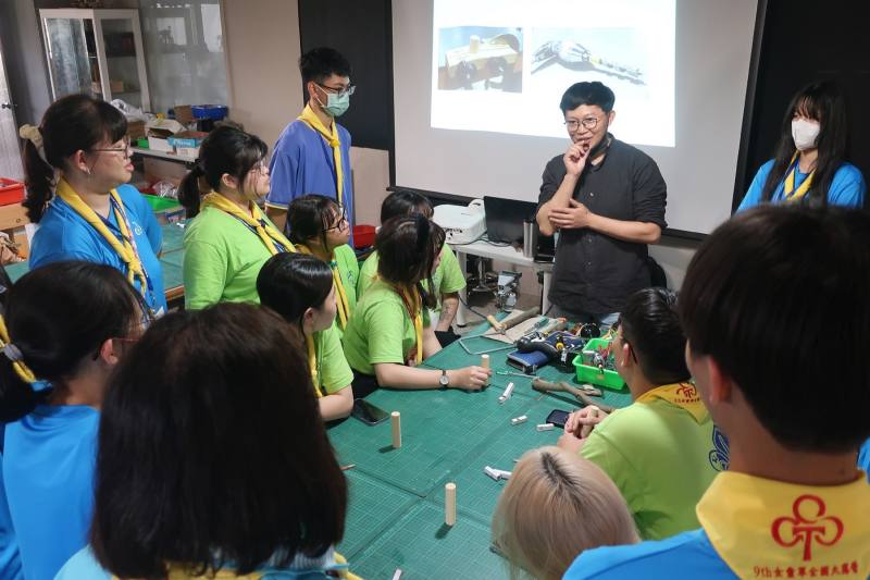 林平勺（右三）在生活科技教室中與學生討論骨牌機關設計，透過耐心指導與啟發