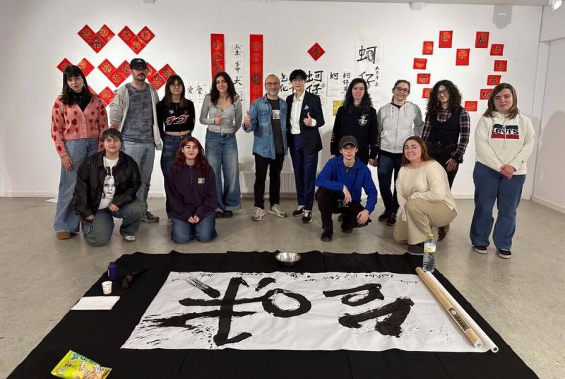 華梵大學美術系助理教授楊侖（後排右5）帶著筆墨紙硯等教材和「蚵仔煎」口味薯片，書法藝術與真實五感體驗結合，帶領西班牙學生舉辦台味書法集體創作。（華梵提供）