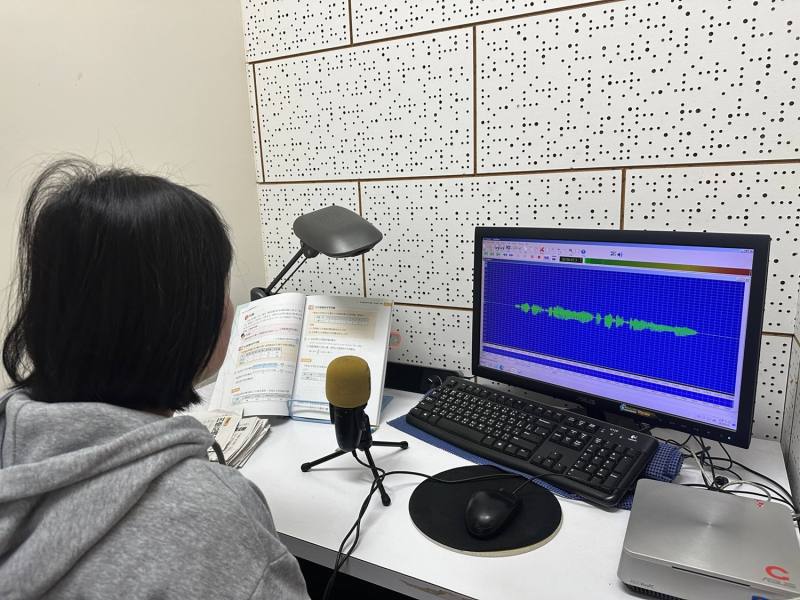 錄音人員依據課本內容錄製有聲書