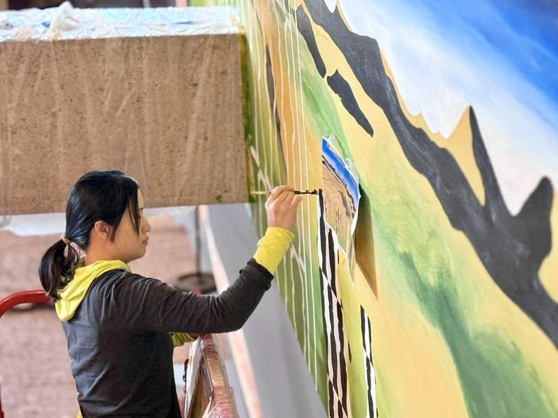 藝術家宜德思．盧信於柏林世界文化之家大型展覽「Musafiri：旅人與賓客」現場繪製壁畫In My World，以復活節島的自然景觀與象形文字為靈感，描繪南島語族的文化與遷徙歷史