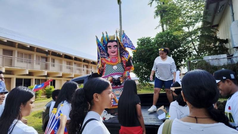 駐帛琉技術團協助帛琉中學於17日至19日規劃辦理「文化意識週」兼「文化競賽週」活動，負責展示台灣文化的學生團隊的遊行前導車有請電音三太子坐鎮「庇佑」。（國合會提供）