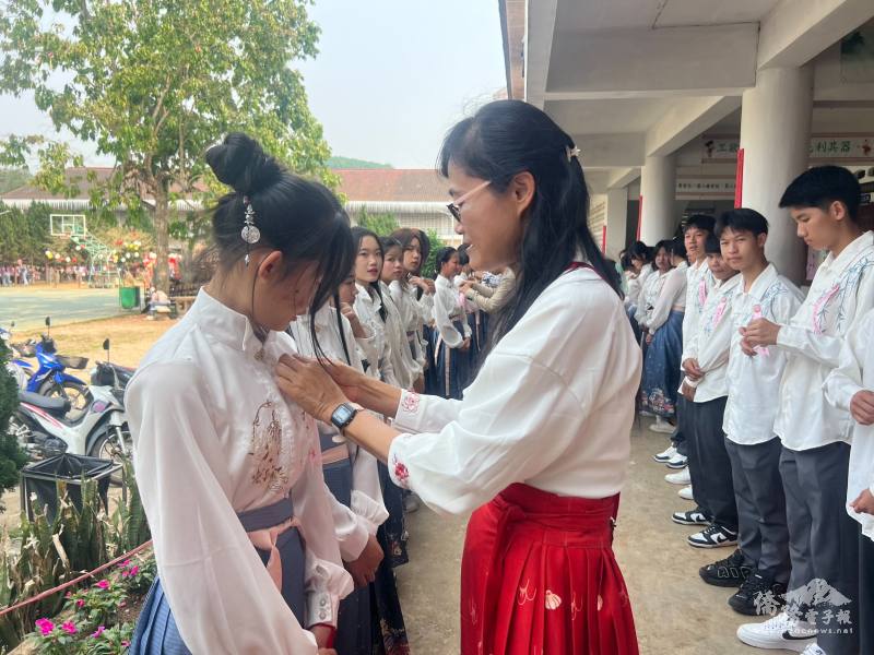 僑委會志工教師卓素惠為畢業生別胸花送祝賀