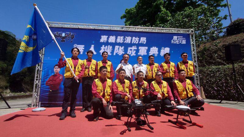嘉義縣消防局提升救災效能，27日在番路鄉天長地久橋舉行無人機隊成軍典禮，由縣長翁章梁（後左4）親自授旗。