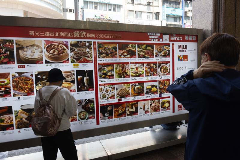 國發會27日公布2月景氣燈號，綜合判斷分數為37分，燈號續亮黃紅燈，其中製造業銷售量指數與批發、零售及餐飲業營業額均轉呈紅燈。圖為民眾觀看台北市一間百貨公司餐廳列表。