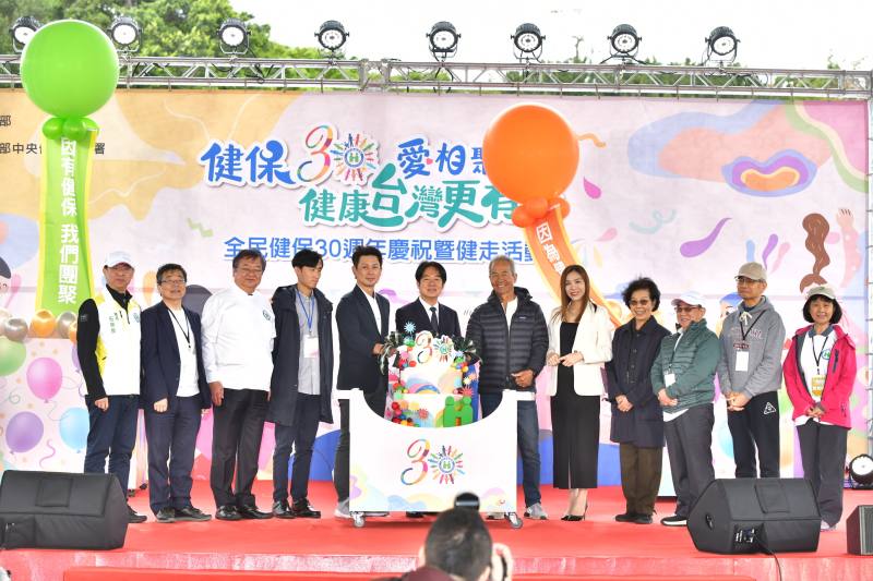 賴清德總統(正中)、衛生福利部邱泰源部長(左3)、周志浩常務次長(左2)及健保署石崇良署長(左1)，偕同健保歷任首長及健保受惠民眾共同切蛋糕