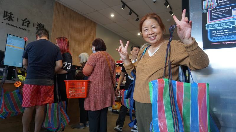 洛杉磯郊區一家專門販售台灣食品的專賣店29日開幕，顧客背著店家贈送的茄芷袋購物。