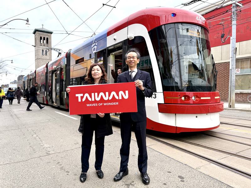 駐多倫多台北經濟文化辦事處長梁毅鵬（右）與台灣觀光署駐紐約辦事處主任莊靜真（左），在多倫多登上台灣觀光彩繪電車前合影。