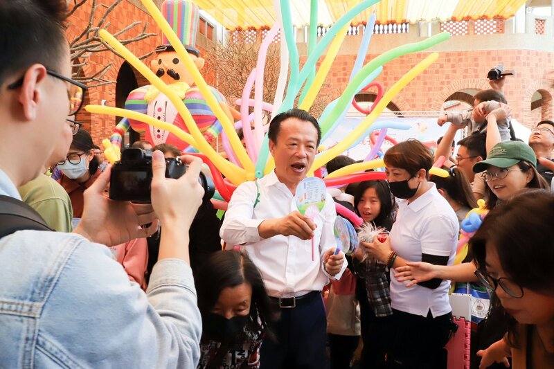 2025嘉義親子藝術節3日在嘉義縣表演藝術中心開幕，縣長翁章梁（中）到場，穿上氣球服裝發送小禮物，場面歡樂。