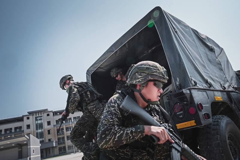 防空群戒護營的一年期義務役官兵，在接獲任務指令後前往戰術位置，並自悍馬車上躍下。