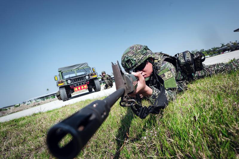 防空群戒護營的一年期義務役官兵，在接獲任務指令後前往戰術位置，並持槍待命警戒。