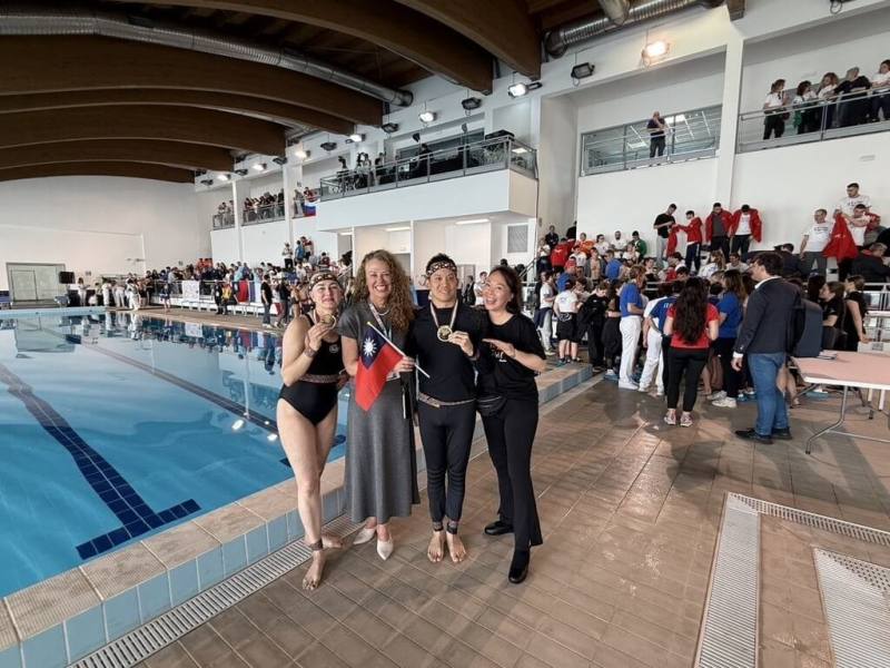 自閉症畫家李柏毅（右2）5日代表台灣參加「多元共融雙人水上芭蕾世界盃」比賽勇奪亞軍，他與教練Julia（左1）、母親簡靜惠（右1）和主辦該世界盃的主席蕭特（Lisa Schott，左2），手持中華民國國旗合照。（簡靜惠提供）