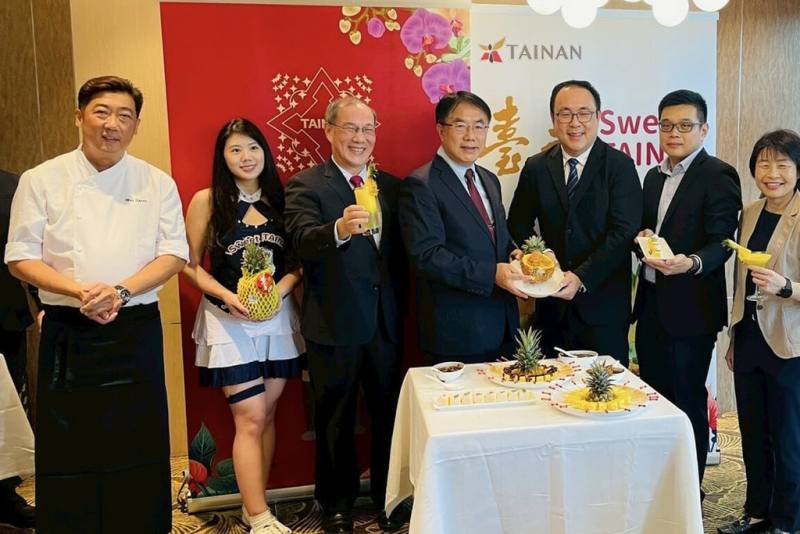 台南金鑽鳳梨4月中下旬將在新加坡連鎖超市10多家門市上市，台南市府7日於當地舉行「台南鳳梨行銷記者會」，市長黃偉哲（左4）親自到場推薦。（台南市政府提供）