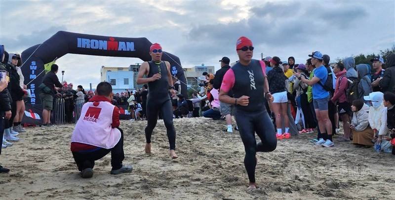 Triathletes run across a beach in Penghu County on Sunday to begin the swimming part of the Ironman Taiwan triathlon. CNA photo April 13, 2025