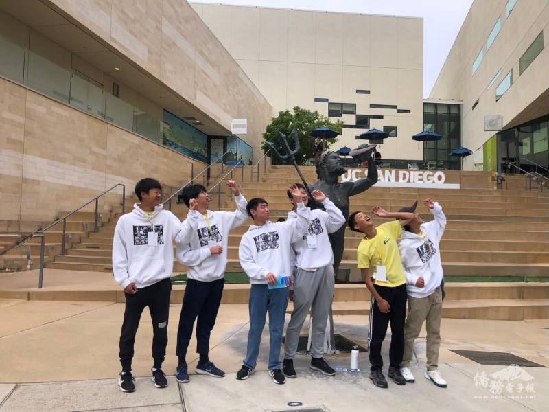 Students show their creativity before the Triton statue during a campus-wide scavenger hunt.