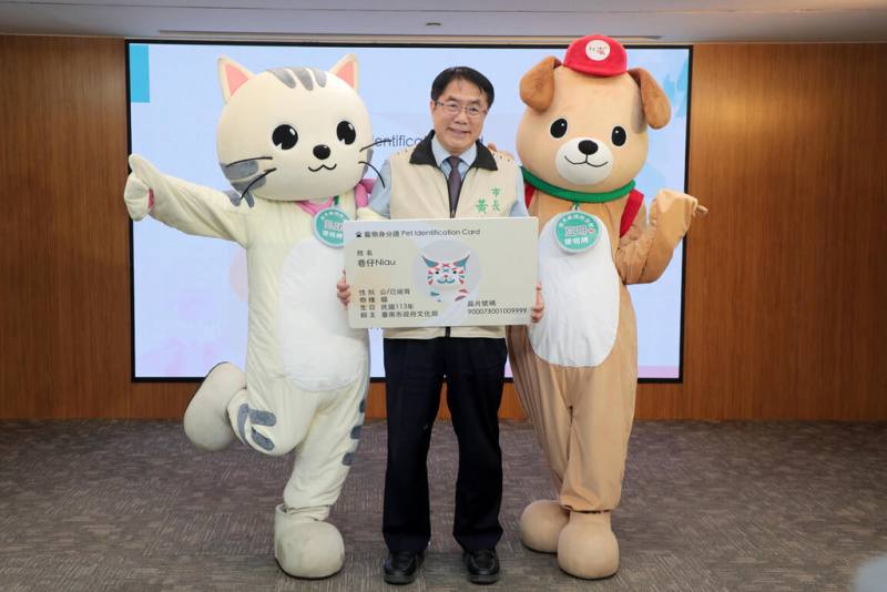 台南市政府15日在永華市政中心舉行家貓納入寵物登記宣導記者會，市長黃偉哲（中）為台南觀光大使「巷仔Niau」領取虛擬寵物身分證。（市府提供）