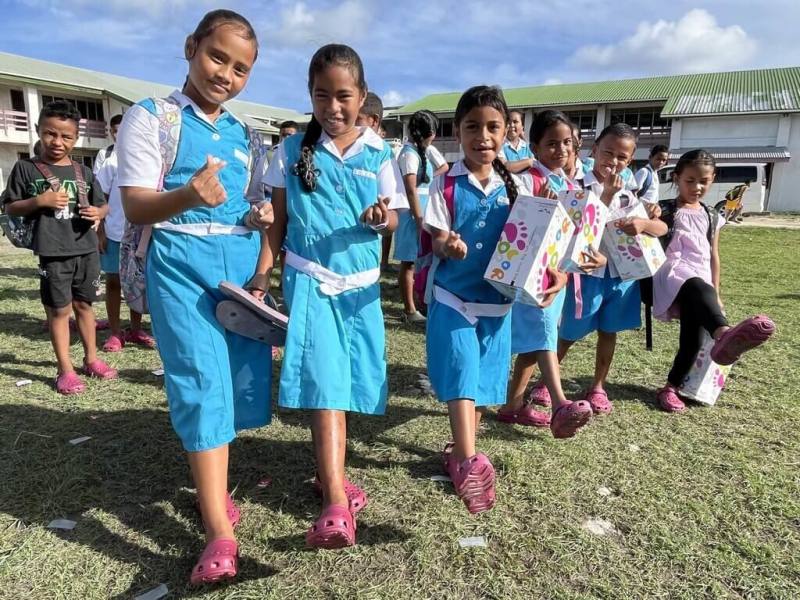 總統賴清德去年出訪吐瓦魯，注意到許多孩子赤腳或穿著夾腳拖，賴總統回台後，特別挑選MIT的洞洞鞋送給孩子們。圖為吐瓦魯學童穿上鞋子的畫面。（總統府提供）