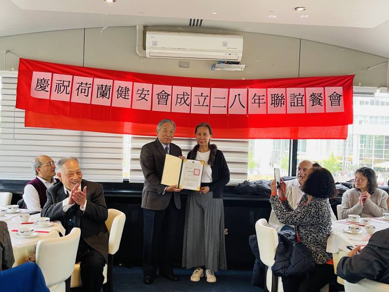 駐荷蘭代表處特任大使田中光(站立左)出席向與會人士表達道賀之意，並頒發僑務顧問聘書予劉舜華(站立右)