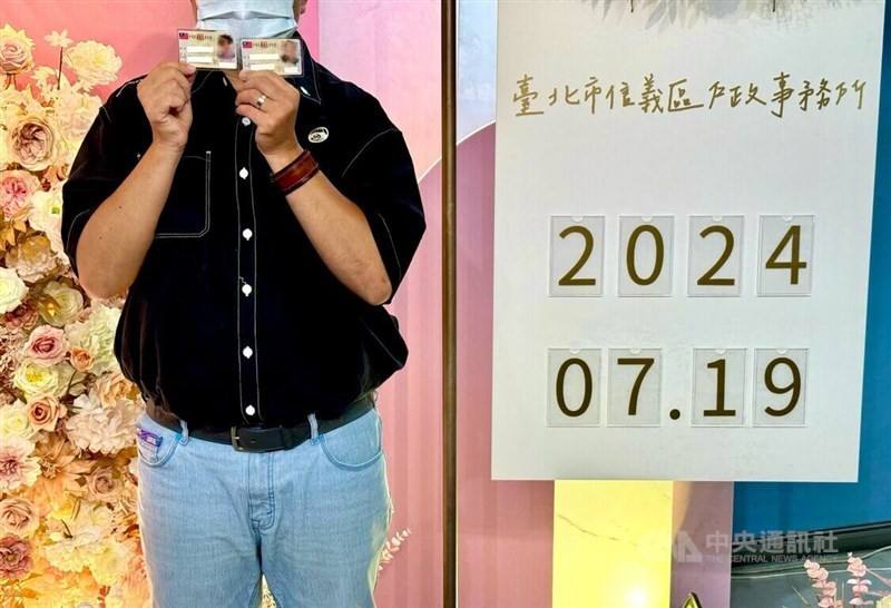 Transgender man Nemo holds up his old ID card alongside his new one, which now lists his gender as male in this CNA file photo.