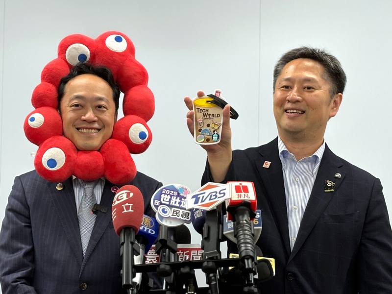 大阪市觀光局萬博促進部長井村悟朗（右）21日秀出參觀Tech World館所獲得的珍珠奶茶造型旅行卡夾，對於Tech World館展示的半導體技術感到驚豔