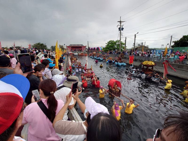 嘉義縣布袋鎮新塭嘉應廟24日舉辦「衝水路、迎客王」活動，轎班抬神轎衝水路具獨特性，吸引滿滿信眾到台17線旁新塭國小西側王爺窟（王船碼頭）圍觀