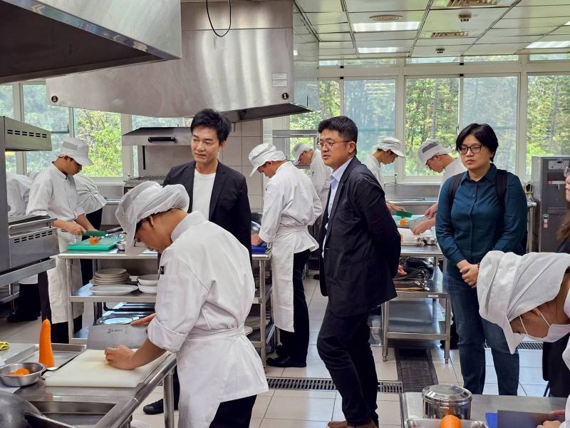 僑生座談會分組觀摩活動，圖為教育部林柏樵主任秘書(左2)與中山工商李昱平校長(左1)協同與會來賓參觀餐飲管理科實作教學
