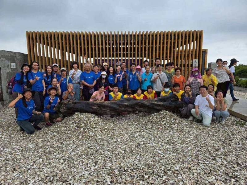 雲林縣成龍社區發展協會邀國內外藝術家駐村創作，藝術行動主題為「土地親像花」，展現成龍濕地多元且富有生命力的風貌，26、27日開幕活動將有市集、音樂演出。圖為民眾與作品「運」合影。（雲林縣府提供）