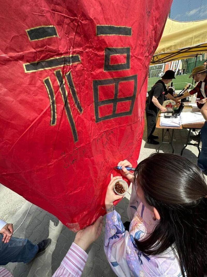 到台灣攤位撰寫天燈祝福文字的同學，另一手還緊緊拿著台灣珍珠奶酪，收穫滿滿。（駐土耳其代表處提供）