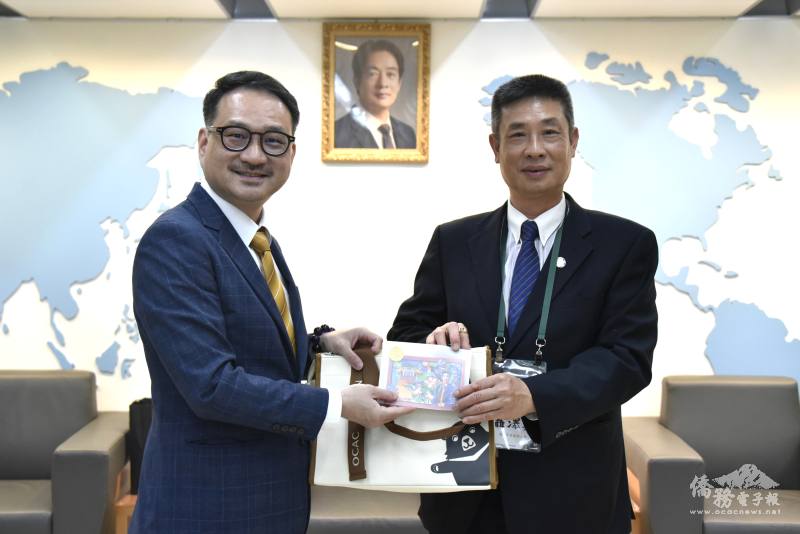 阮昭雄(左)致贈紀念品與國父逝世百週年紀念郵票，由主席聶澤英(右)代表受贈