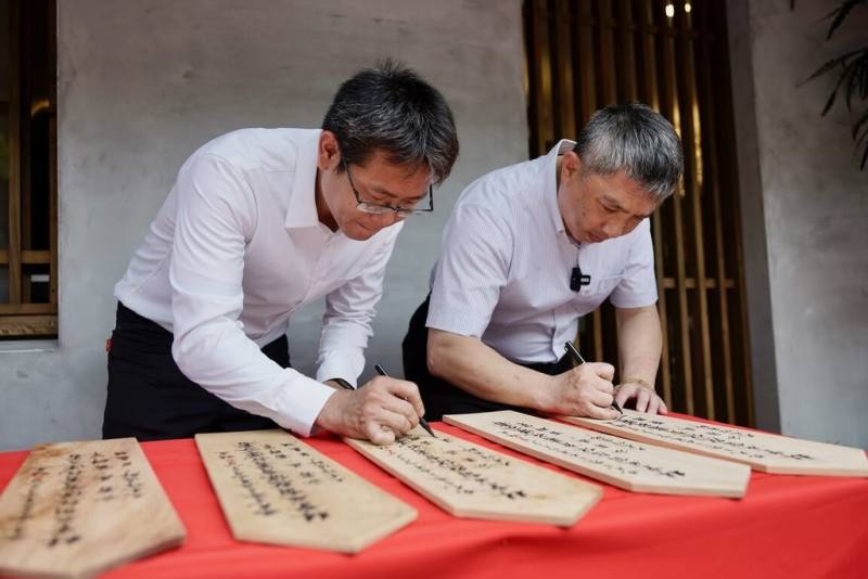 林業及自然保育署花蓮分署歷時1年多修繕，林田山房舍修復及再利用第二期工程28日啟用，由花蓮分署長黃群策（右）與木作匠師吳嘉祥（左）共同簽署棟札儀式，象徵修復工程的負責與承諾。（林保署花蓮分署提供）