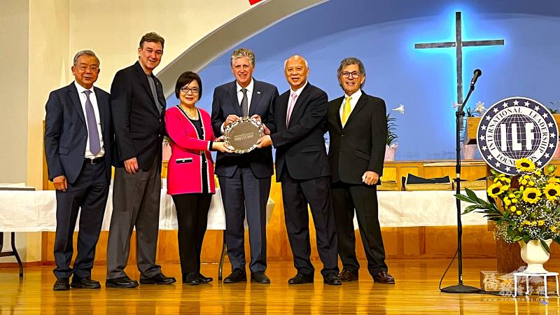 國際領袖基金會共同創辦人董繼玲(左三)、Joel Szabat(左二)和路加基金會3名共同創辦人，吳子平(左一)、葉超(右二)、畢靈頓(右一)聯袂送紀念品給羅德島州州長Dan Mckee(右三 )