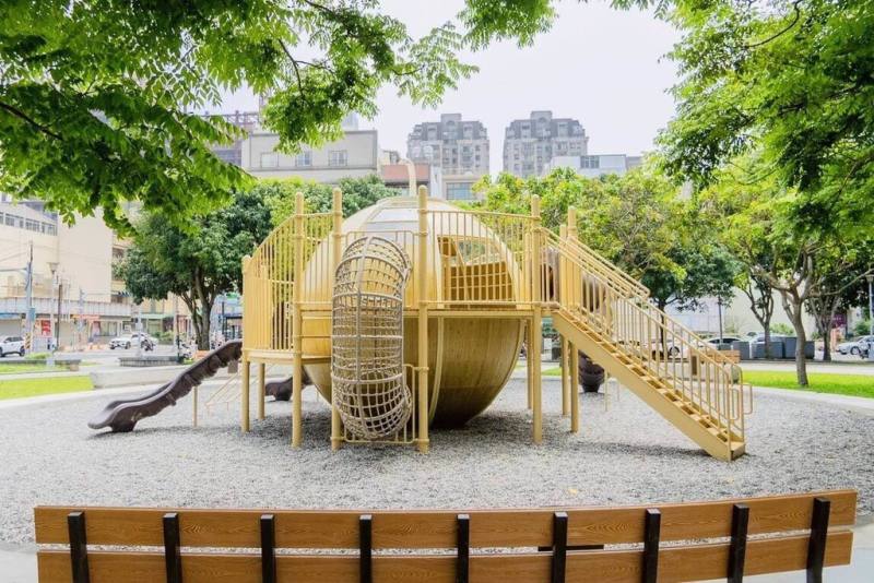新竹縣竹北市莊敬六街的蔬果公園以土星意象設計共融遊戲場，採用沙黃色為主色象徵土星表面，搭配環形平台、三道滑梯、穿越型爬網等設施，打造宛如星系般的動線。（竹北市公所提供）