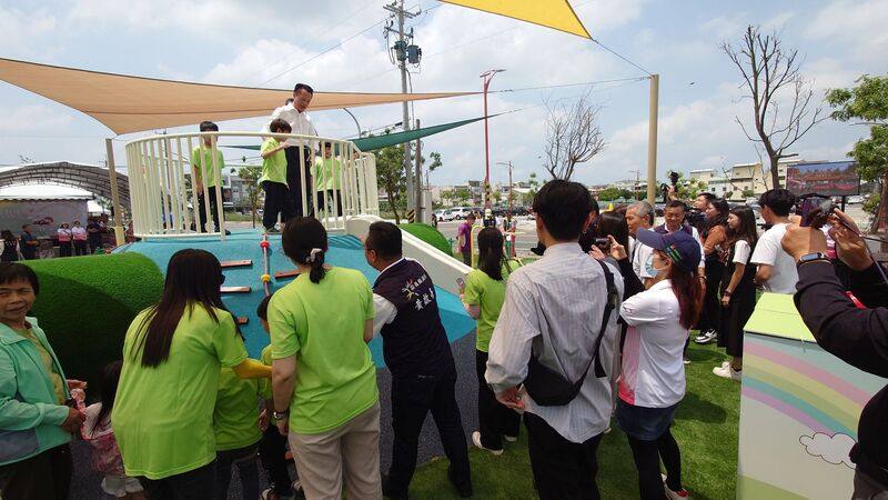 中央補助興建嘉義縣新港鄉嘉民行政園區兒童遊戲場30日啟用，嘉義縣長翁章梁（後左，白襯衫者）到場，與幼稚園小朋友同樂。