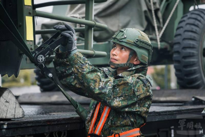 綑綁組官兵以手拉器收緊繩索至緊繃狀態，確保車輛牢固於板車上。（青年日報提供）