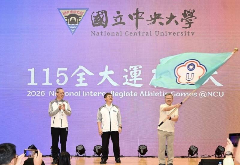 114年全國大專校院運動會2日在台南長榮大學舉辦閉幕典禮，並將會旗交接給中央大學，宣告115年全大運將在桃園舉行。圖為中央大學校長蕭述三（右）在閉幕式中揮舞旗幟。（長榮大學114全大運執行辦公室提供）