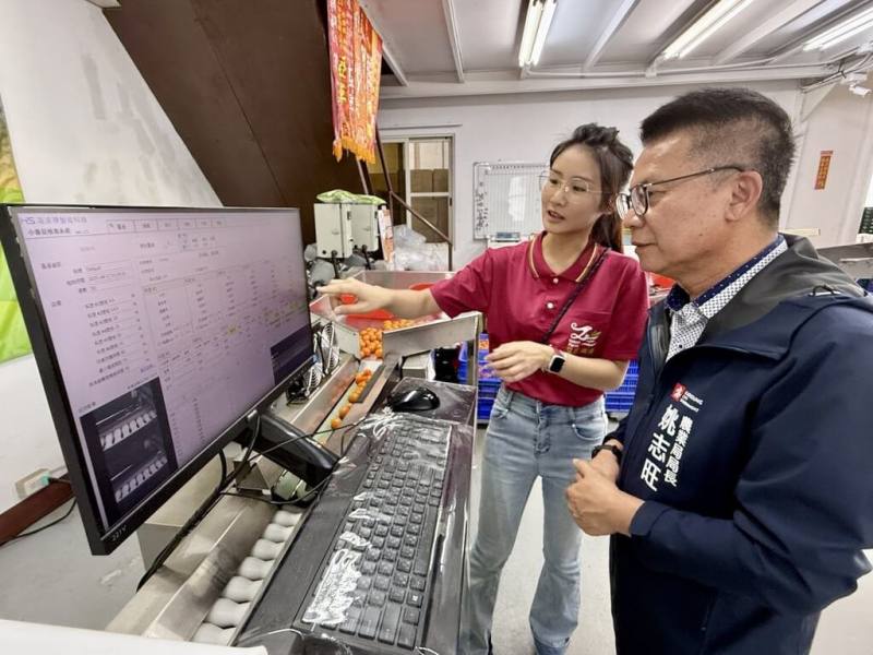 高雄市農業局將AI技術導入「智慧分級」系統，提升選果效率與精準度；高雄市農業局長姚志旺（右）也親自前往農場了解設備開發情形。（高雄市農業局提供）