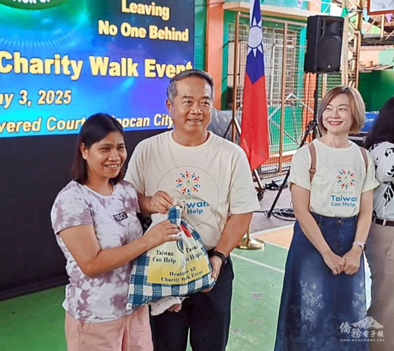 駐菲律賓代表處大使周民淦（中）分送善心米等物資給菲國民眾